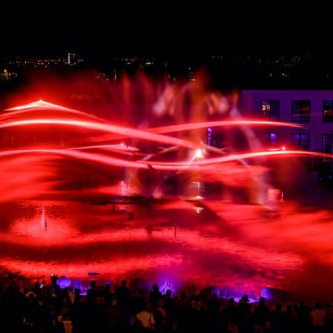 Rote Laserwellen auf der Wasserleinwand